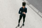 Joggerin schaut auf Tracker Joggerin schaut auf Tracker